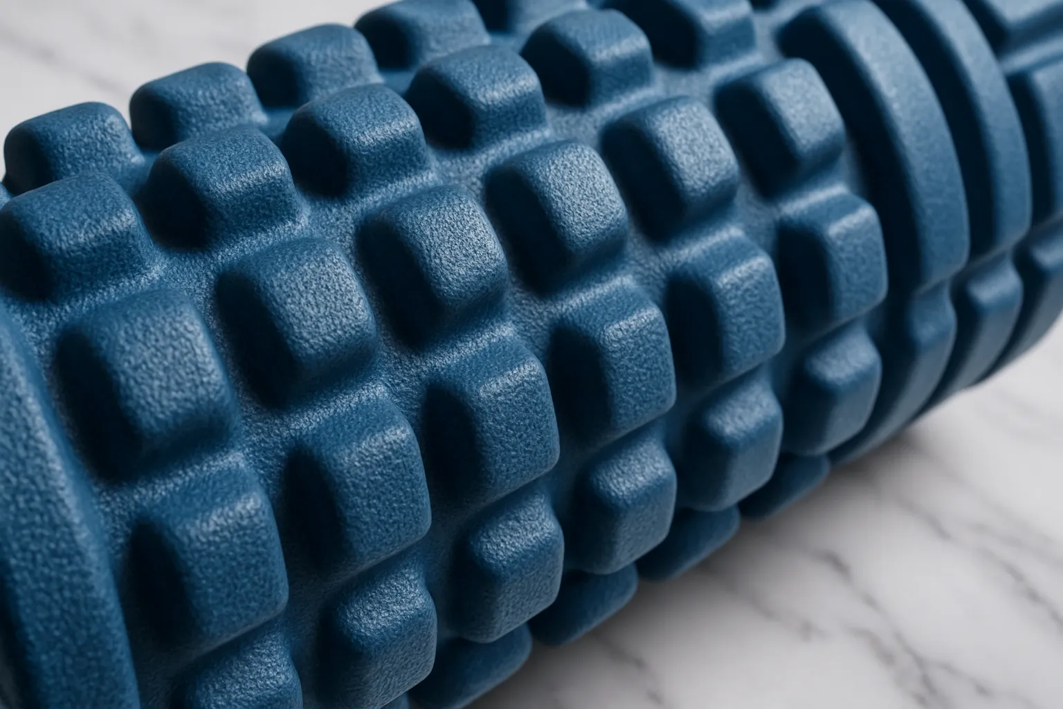 Detalhe macro de rolo de liberação miofascial texturizado mostrando superfície com nódulos para massagem de tecidos profundos